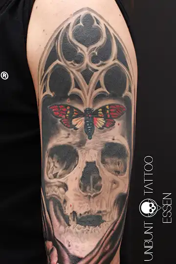 realistisches totenkopf tattoo oberarm frau mit kirchenfenster